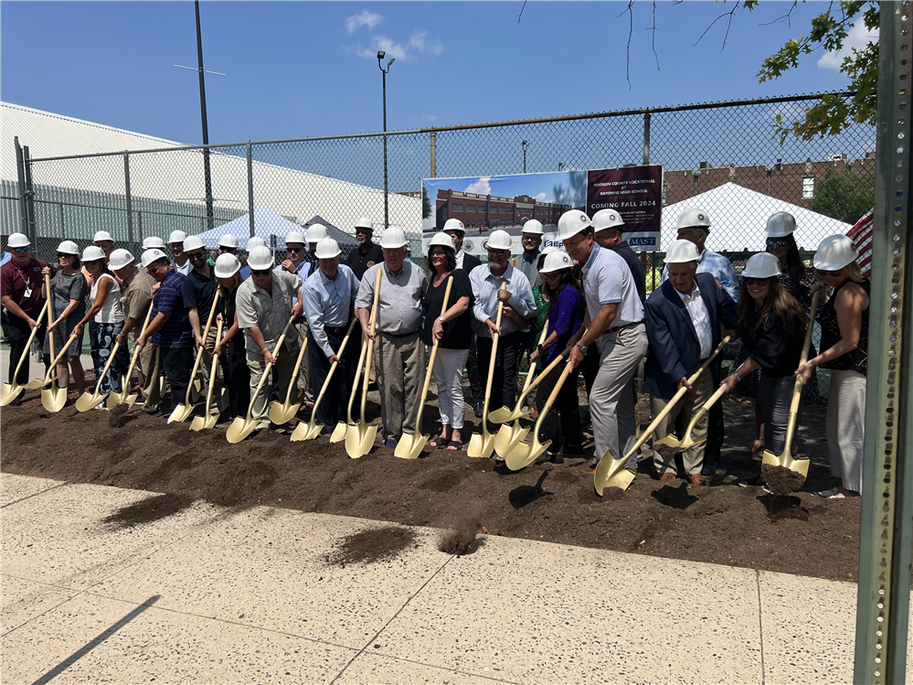  Group of individuals from Hudson County with shovels digging into dirt.